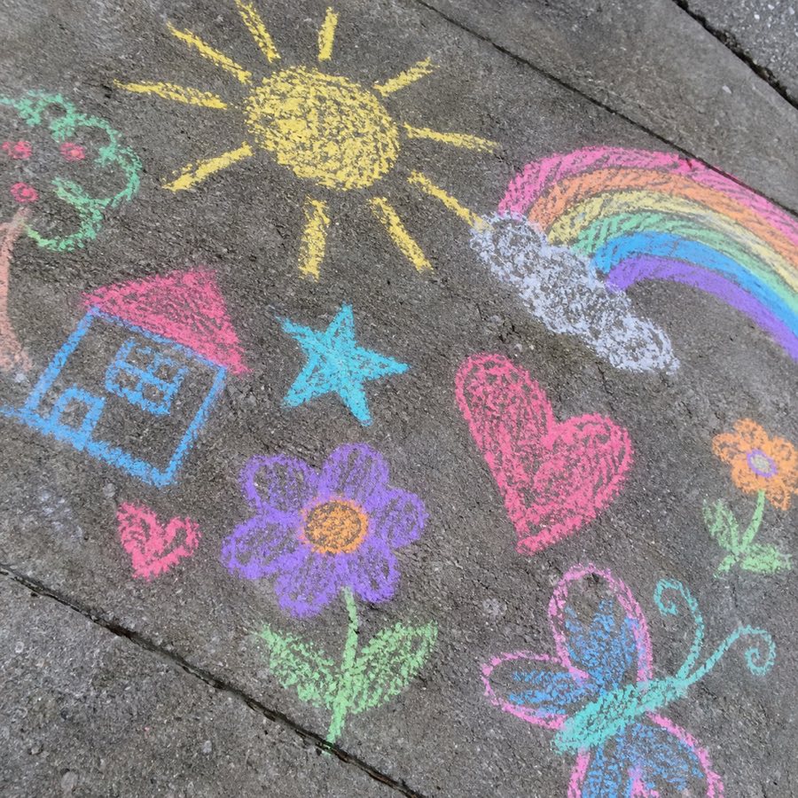 Chalk drawings on grey pavement, shot from above at an angle